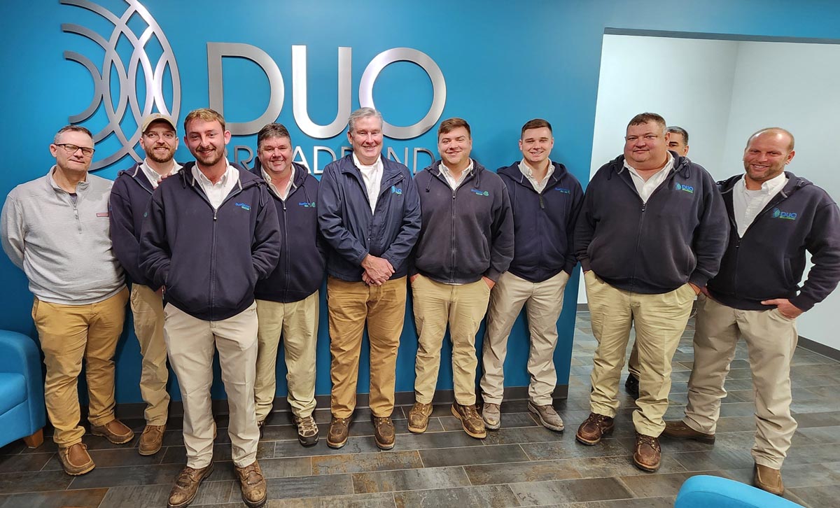 image of DUO Broadband employees surrounding David Robertson
