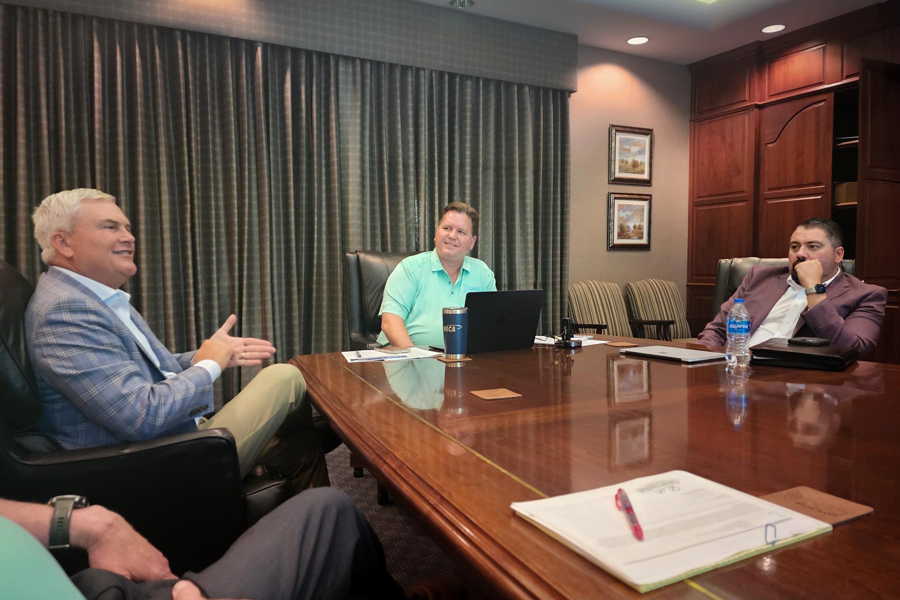 Three men at a conference table