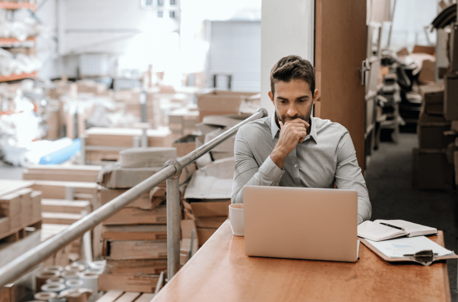 Man looking at computer surrounded by workplace