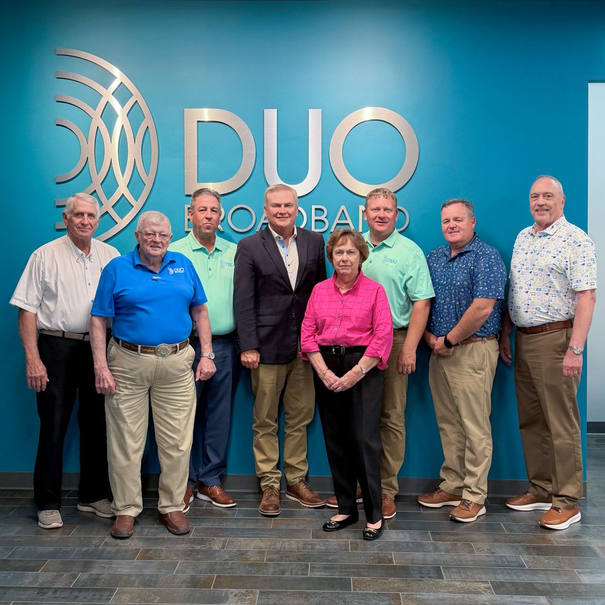 group of people in front of a DUO Broadband logo
