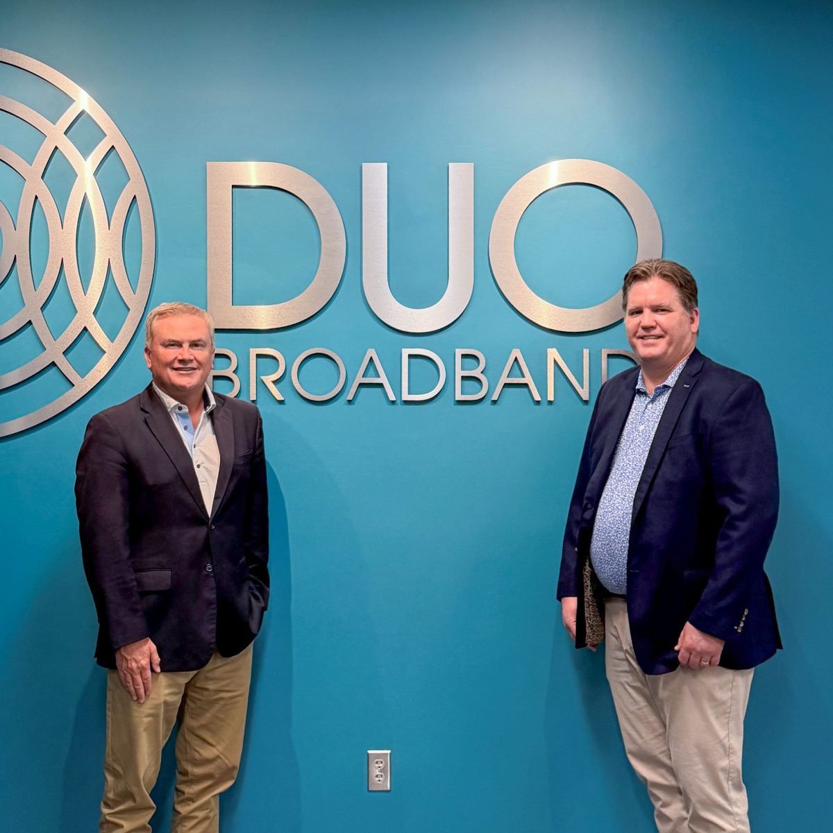 group of people in front of a DUO Broadband logo